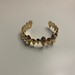 Gold bangle with crystal embellishments.
